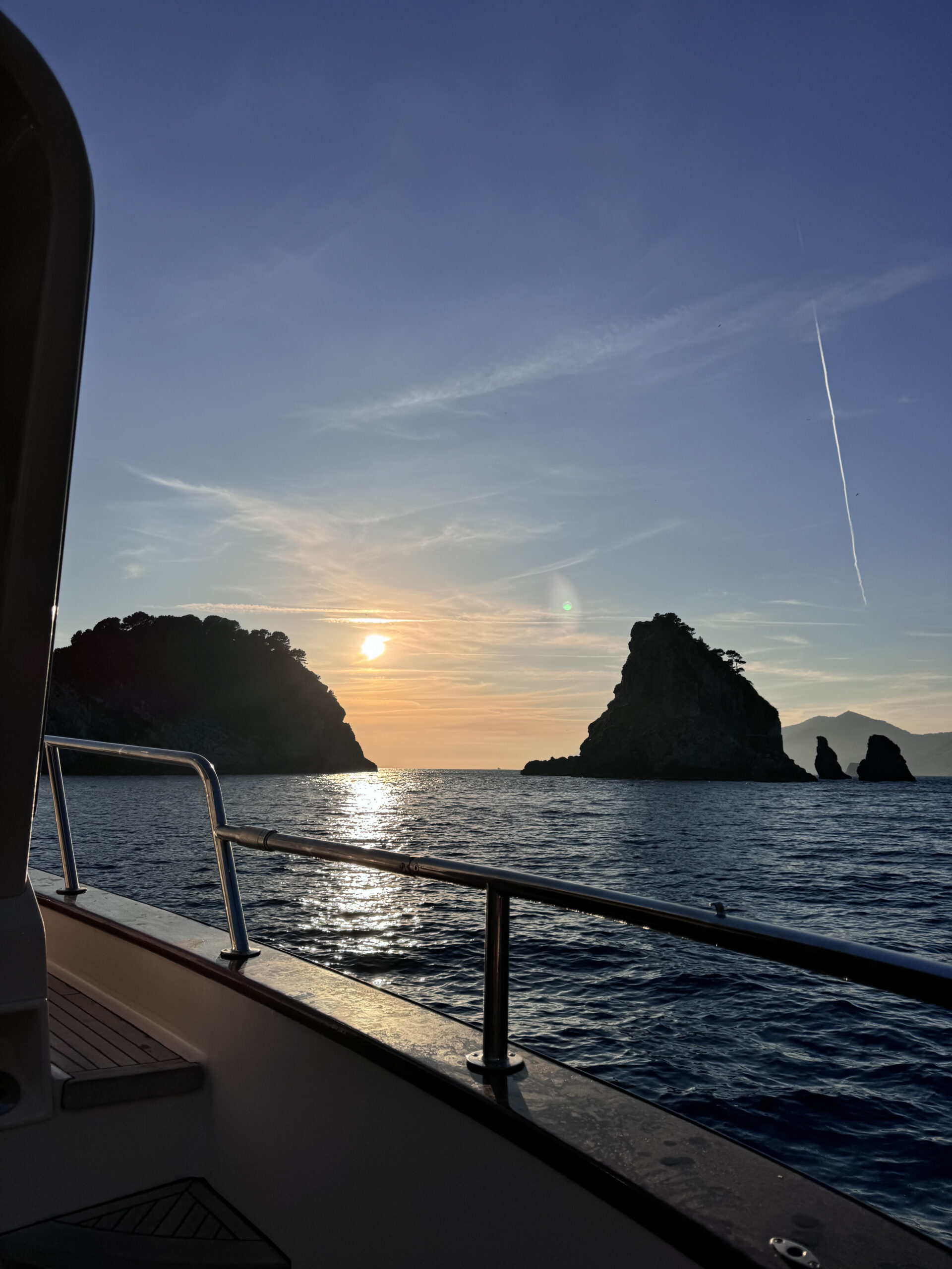 Sunset view from a boat near Li Galli and Nerano with rocky islets in silhouette
